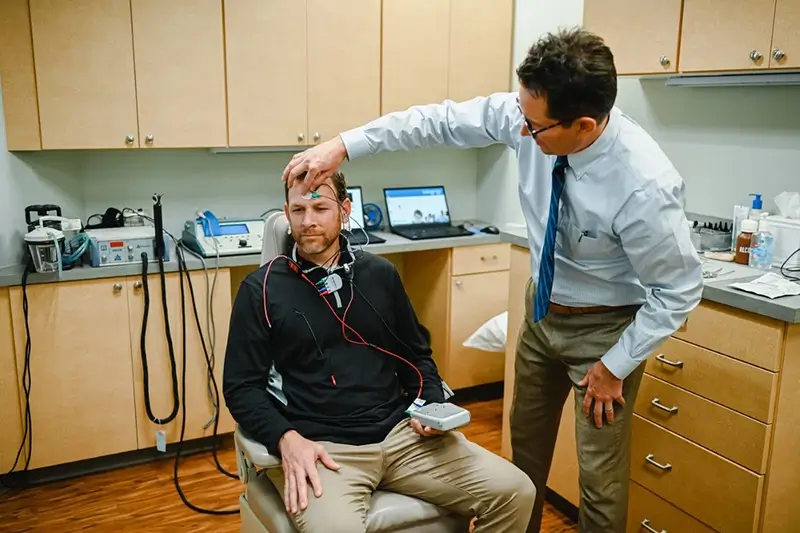 audiologist conducts an examination on a patient